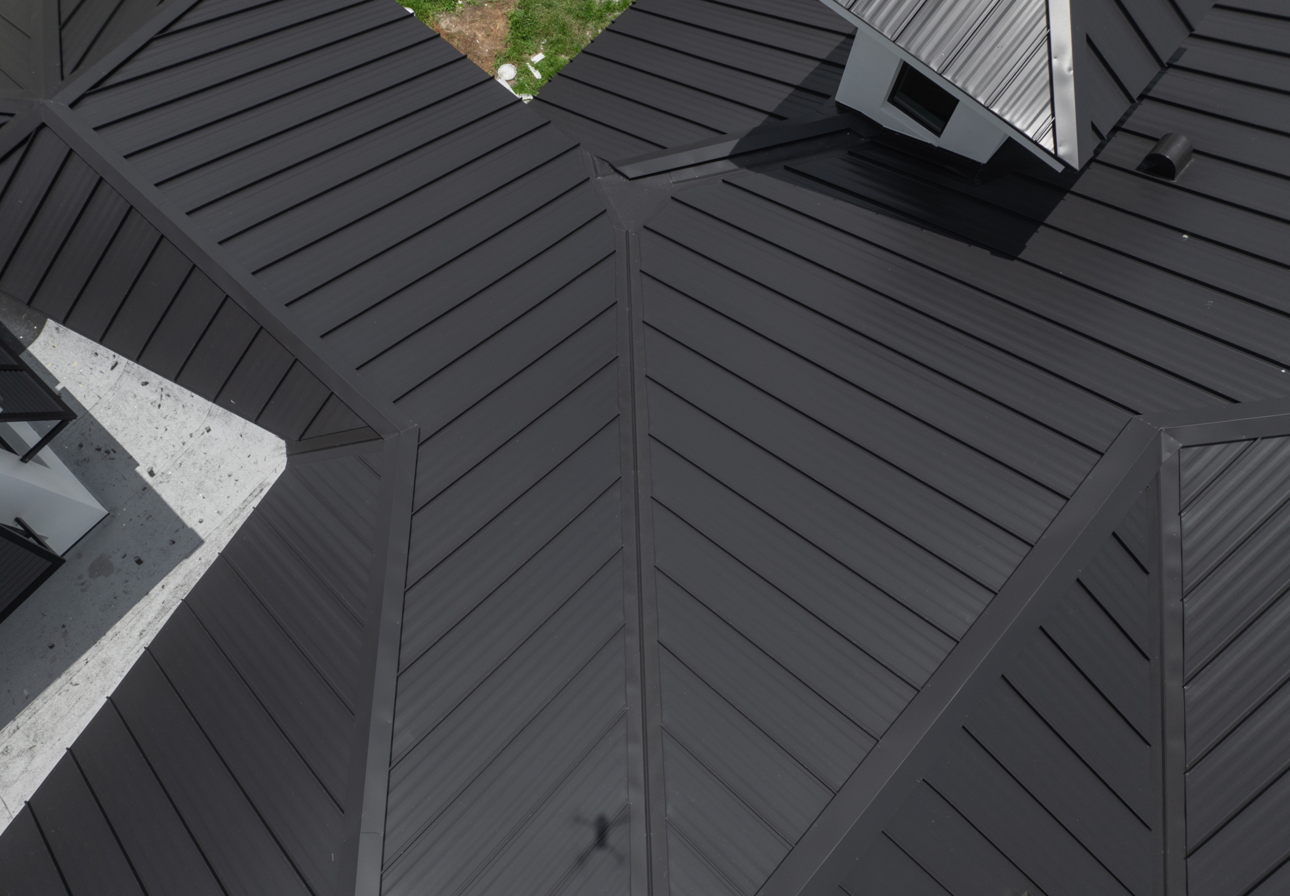 Standing seam metal roof panels running from eave to ridge